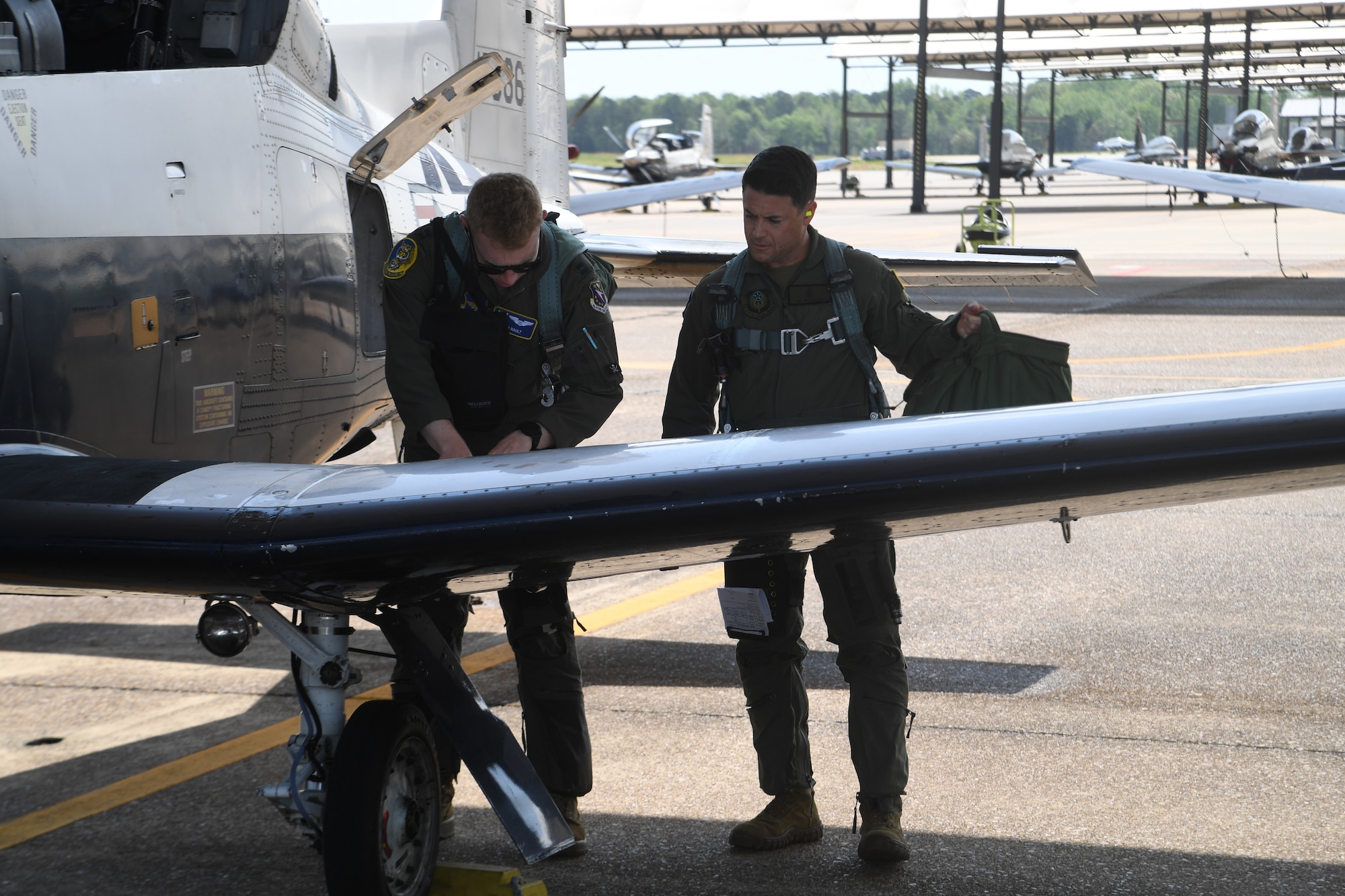 Maj. Owen John Williams goes over the preflight checklist with pilot Capt. Michael Nault prior to his orientation flight