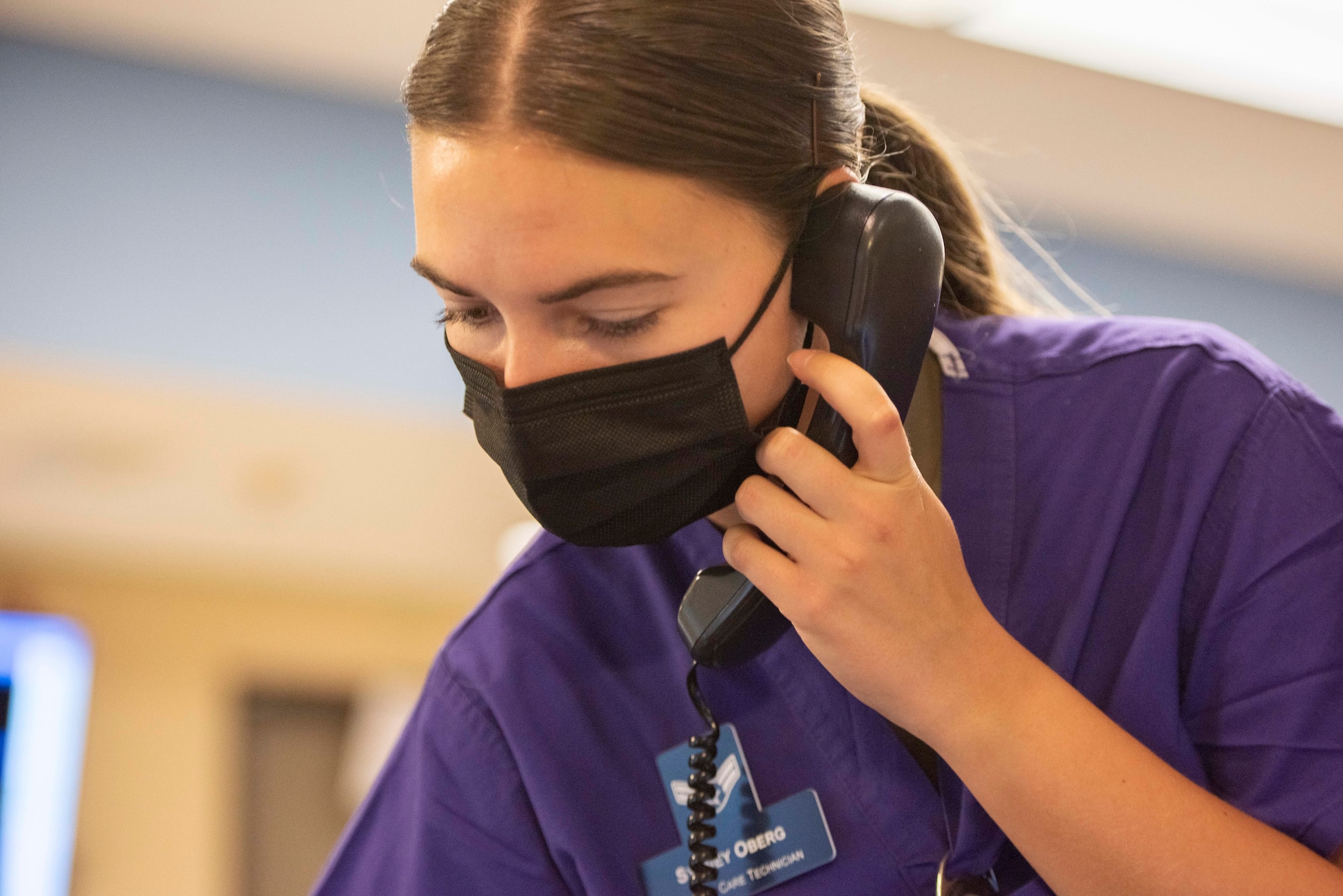 An Airman holds a phone while placing a call.