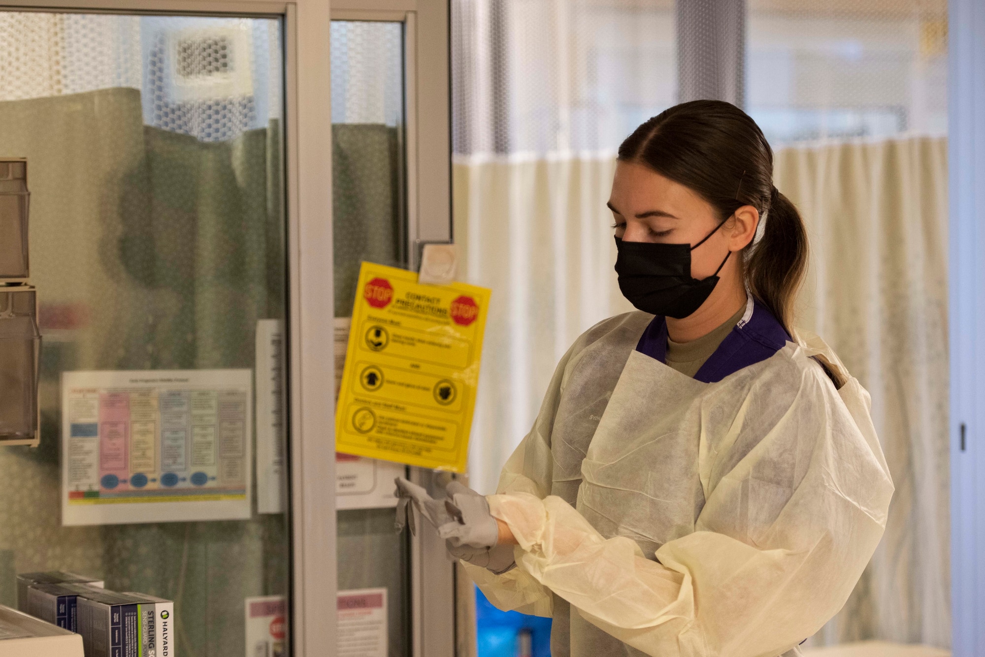 An Airman puts on personal protective equipment.