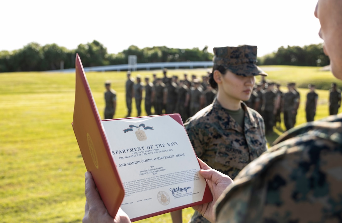 U.S. Marine Corps Cpl. Aselia Isakova, a chemical, biological, radiological and nuclear specialist with Headquarters Battalion, 3d Marine Division, is awarded the Navy and Marine Corps Achievement Medal at Camp Courtney, Okinawa, Japan, April 8, 2022.