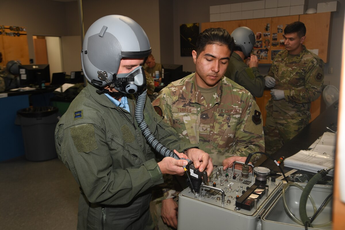 Dr. John Gassaway receives instruction on how to operate the oxygen system at the aircrew flight equipment shop
