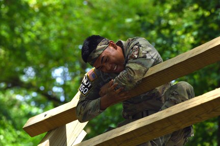 Army Sgt. Fred Lino Jr., a small arms/artillery repairer with the Hawaii Army National Guard’s 29th Brigade Support Battalion, makes his way up a log barrier at an obstacle course event at the Army National Guard’s 2022 Best Warrior Competition at Volunteer Training Site-Milan, Tennessee, July 26, 2022.