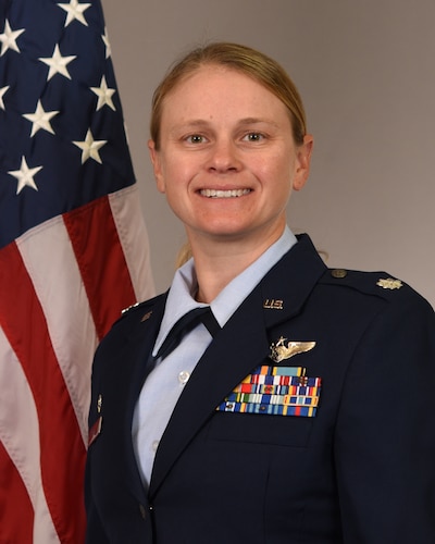 photo of USAF Airman in front of U.S. flag