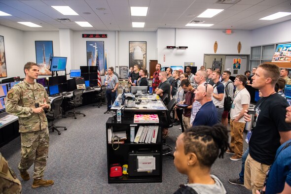 U.S. Air Force Maj. Nathan Motz, 45th Weather Squadron, delivers a mission briefing to participants of the BRAVO Hackathon during a tour of the Morrell Operations Center July 19, 2022, at Cape Canaveral Space Force Station, Fla. The event brought engineers, scientists, and coders together from four countries to solve problems with the launch mission. (U.S. Space Force photo by Amanda Inman)