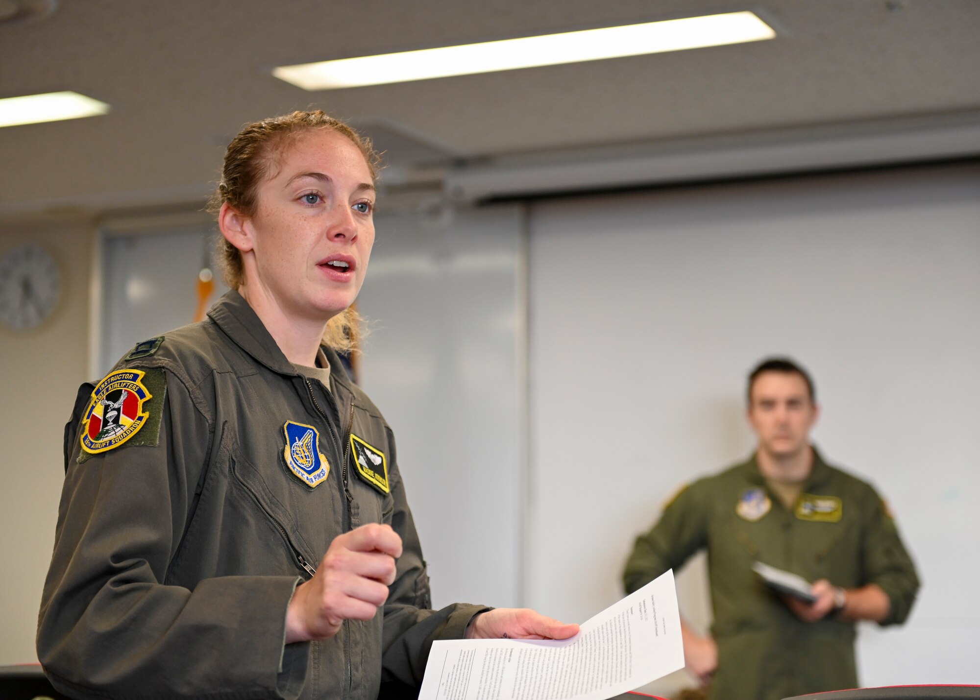 A female pilot speaks to a meeting in a conference room