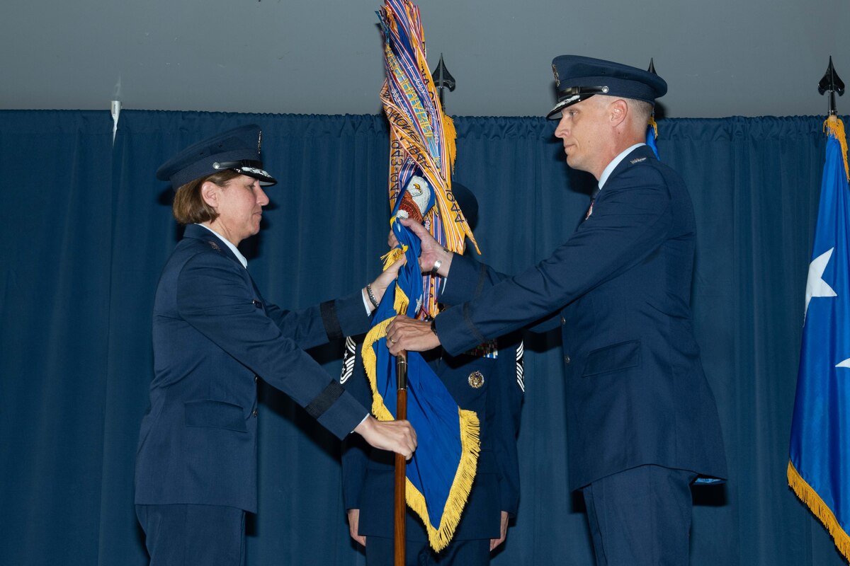 Lt. Gen. Andrea Tullos, Air University commander and president, passes the 42nd Air Base Wing guidon to Col. Ryan Richardson during the wing's change of command ceremony, July 29, 2022. During the ceremony, Col. Eries Mentzer relinquished command of the wing to Richardson. Richardson's previous assignment was director, Manpower, Personnel and Services, Headquarters U.S. Air Forces in Europe-Air Forces Africa, Ramstein Air Base, Germany.
