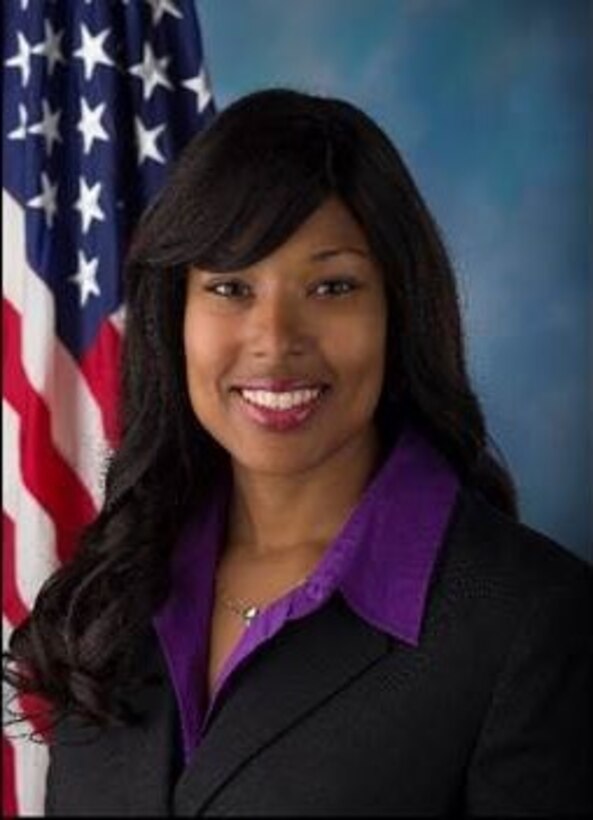 Ms. Kishayra Lambert poses for a photo in front of an American flag.