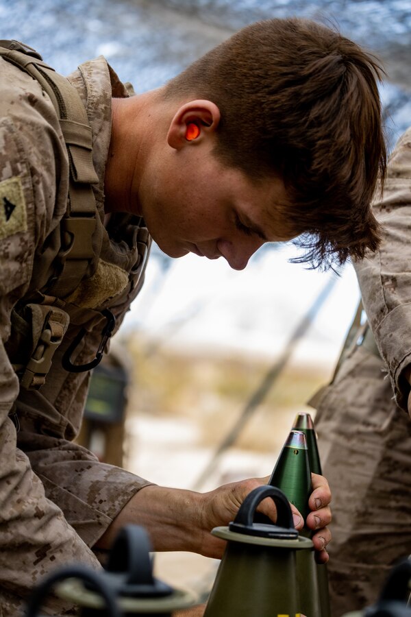 U.S. Marine Corps Lance Cpl. Clayton Cole, a field artillery cannoneer with Sierra Battery, 2nd Battalion, 10th Marines, prepares a M1122 High Explosive round during Integrated Training Explosive 4-22 at Marine Corps Air Ground Combat Center, Twentynine Palms, Calif., July 27, 2022. Marines from 10th Marines are augmenting 3rd Battalion, 14th Marine Regiment, as the Active and Reserve Components continue to integrate to increase proficiency of Total Force operations. (U.S. Marine Corps photo by Cpl. Ryan Schmid)