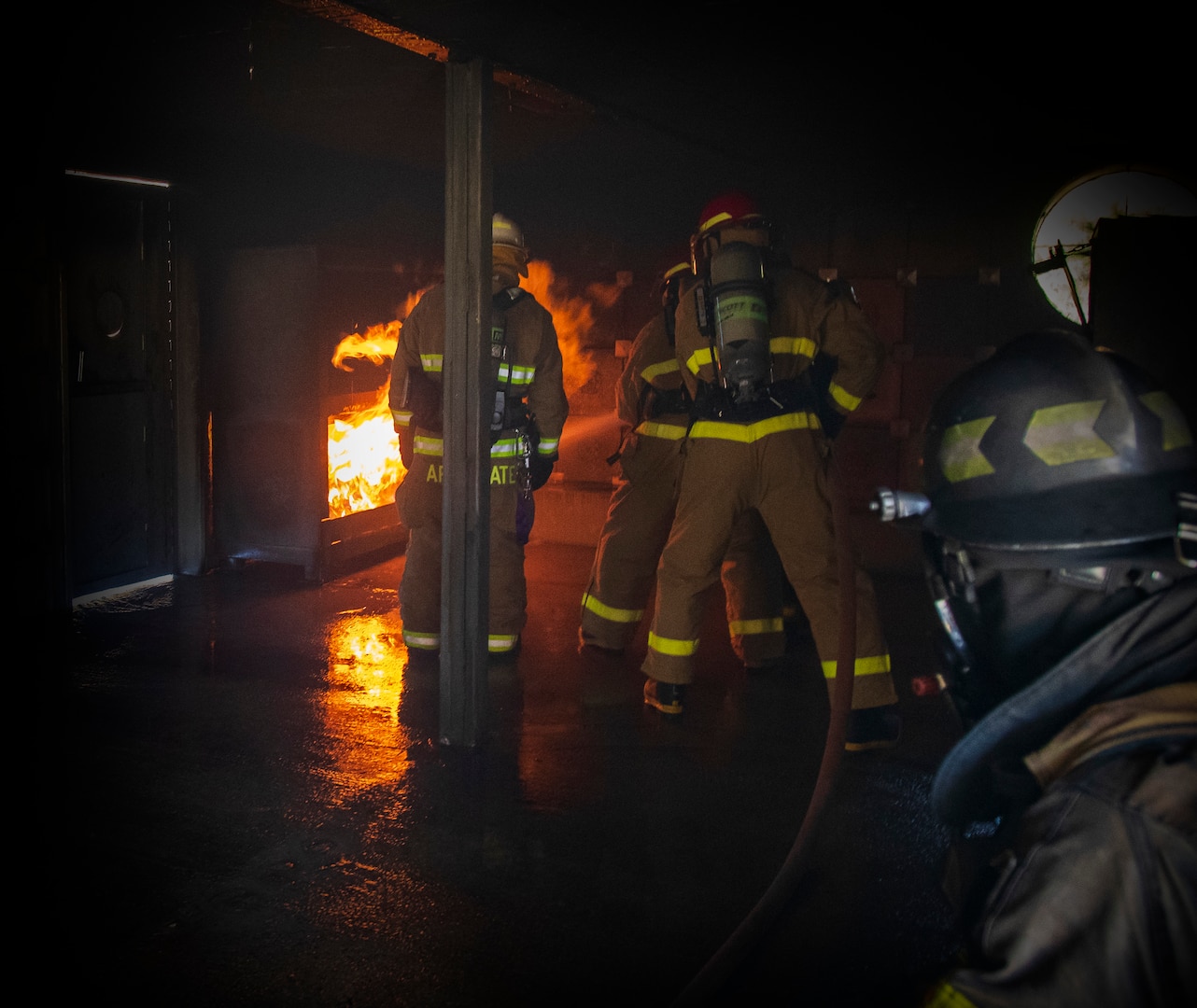 Battalion Chief of Training Mike Applegate (left) observes firefighting inside a training structure designed to simulate a ships galley. (U.S. Navy Photo by Wendy Hallmark)