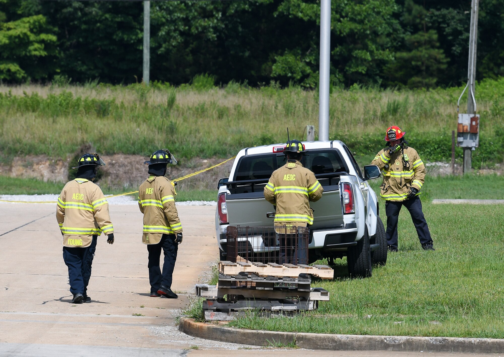 Four emergency responders looking at a truck