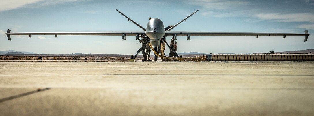 A U.S. Air Force MQ-9 Reaper with the 163rd Attack Wing, California Air National Guard, refuels during Integrated Training Exercise 4-22 at Marine Corps Air-Ground Combat Center, Twenty-nine Palms, Calif., on July 20th, 2022. The MQ-9 Reaper received fuel via aviation delivered ground refueling from an MV-22 Osprey with Marine Medium Tiltrotor Squadron 764, marking the first time the MQ-9 received fuel from a joint asset and the first time an Air National Guard MQ-9 received fuel from another aircraft. The MQ-9 Reaper provided close air support to Marine Air-Ground Task Force 23 during its execution of the fire support coordination exercise of ITX as the Marine Corps Reserve continues to work to integrate with sister services in preparation for future operations.