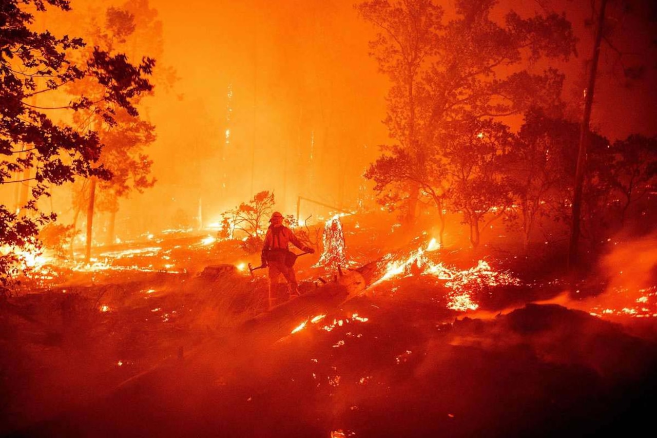A firefighter is surrounded by orange flames.