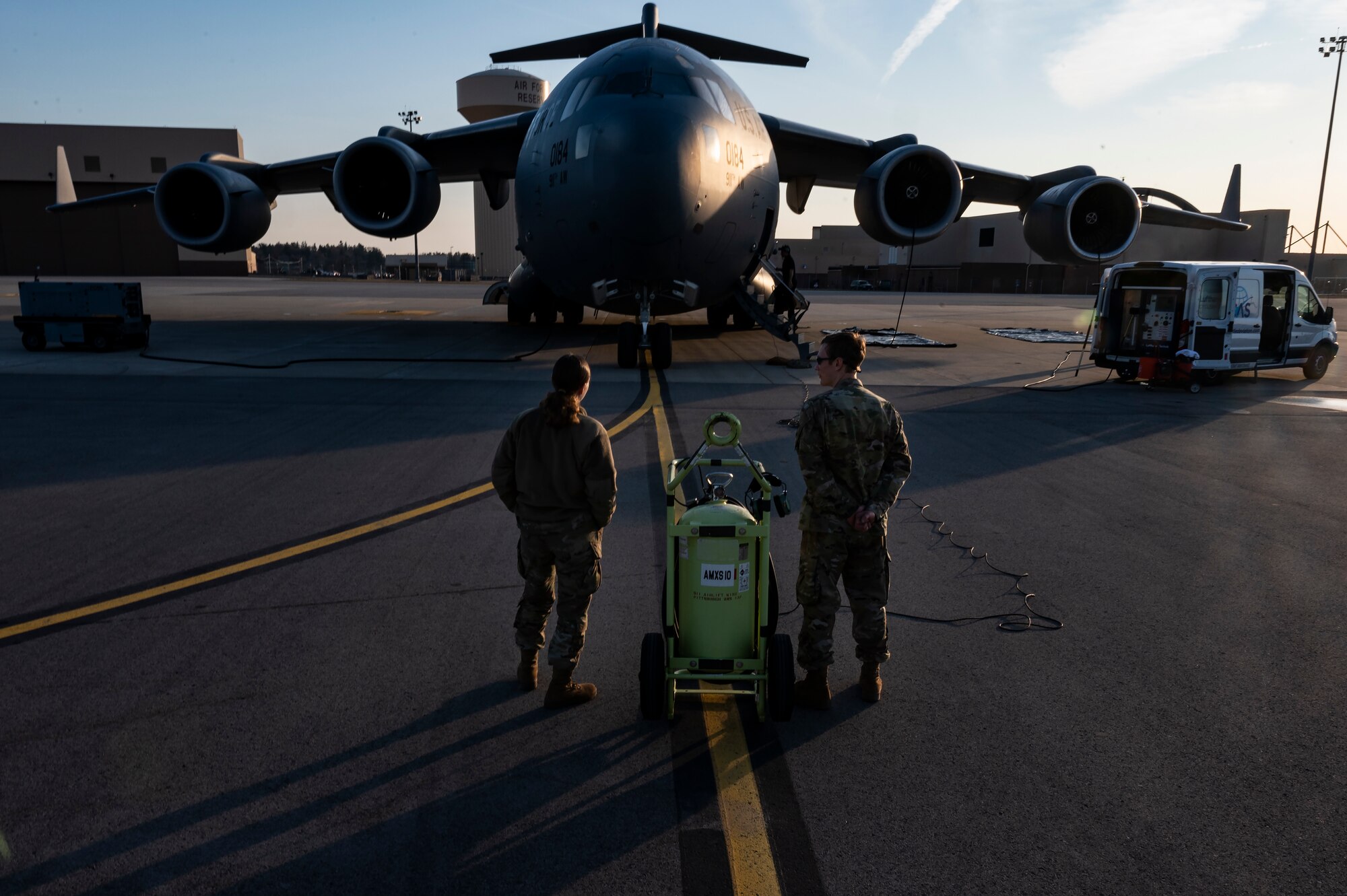 Airman 1st Class Kassidy Ohler and Airman 1st Class Liam Pritchard, 911th Maintenance Squadron aerospace propulsion technicians, talk while waiting for an eco-wash on a C-17 Globemaster III's engines to begin at the Pittsburgh International Airport Air Reserve Station, Pennsylvania, March 18, 2022.