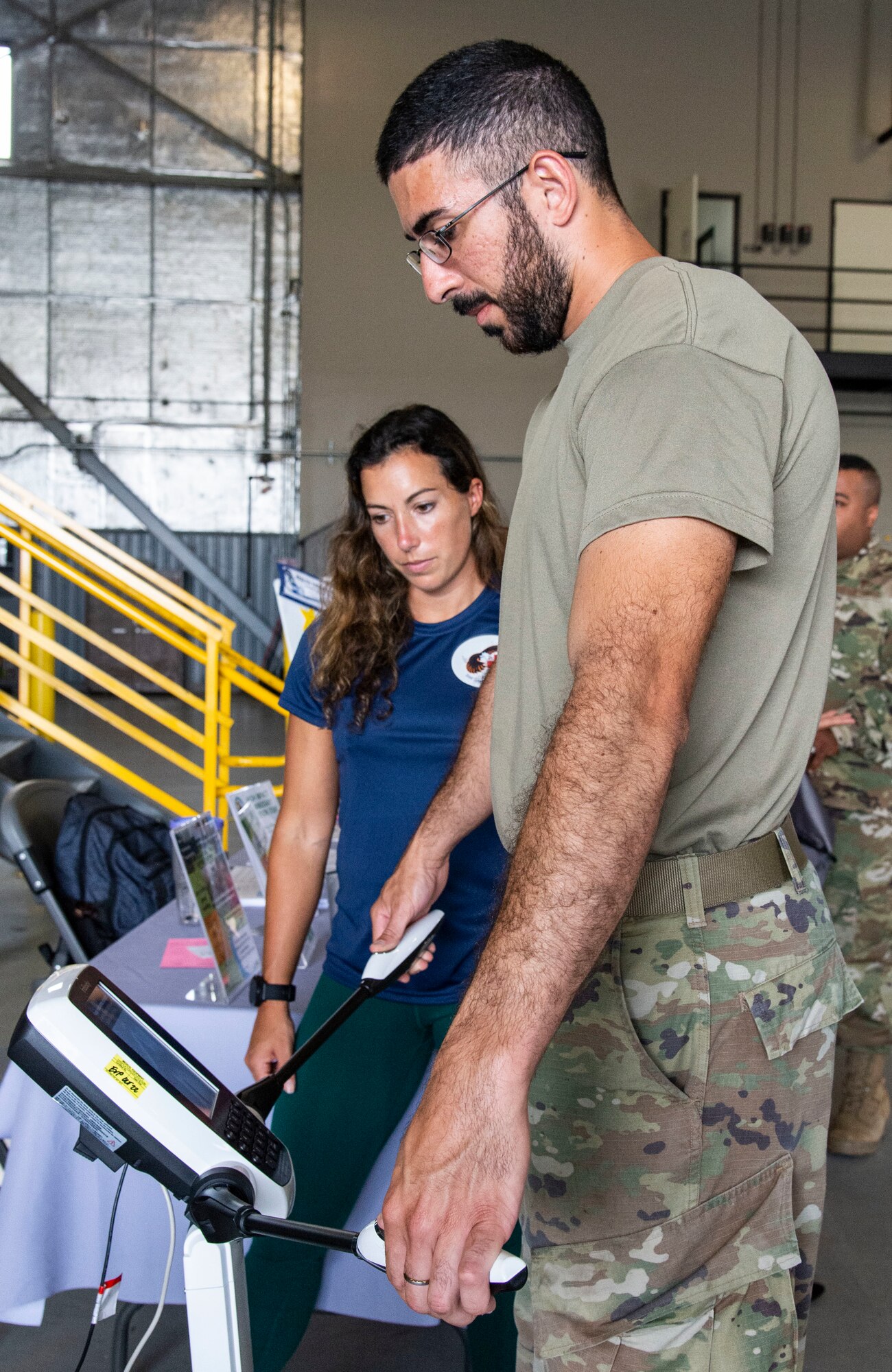 Senior Airman Lucas Barbosa, right, 436th Civil Engineer Squadron water and fuel systems maintenance journeyman, records his body mass index while Catherine Paape, left, 436th Operational Medical Readiness Squadron operational support team strength coach, observes the results during The Whole Airmen Festival on Dover Air Force Base, Delaware, Aug. 1, 2022. The festival was organized and hosted by the 436th Aircraft Maintenance Squadron Integrated Resiliency Team, which brought more than 20 on-base resources pertaining to education, health and wellness services to one location. (U.S. Air Force photo by Roland Balik)