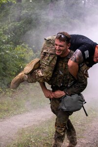 A soldier uses the fireman's carry to mve another soldier.