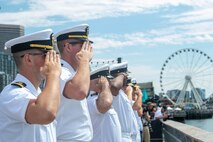 United States Navy and Royal Canadian Navy officers salute the arrival of the Royal Canadian Navy in Seattle for Fleet Week, Aug. 1, 2022.