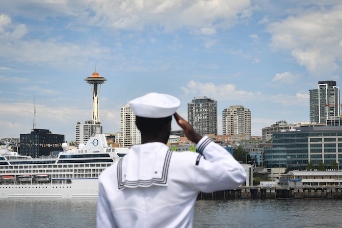 A Sailor renders "passing honors" aboard the Ticonderoga-class guided-missile cruiser USS Lake Champlain (CG 57) during the parade of ships, August 1 in support of Fleet Week Seattle 2022.