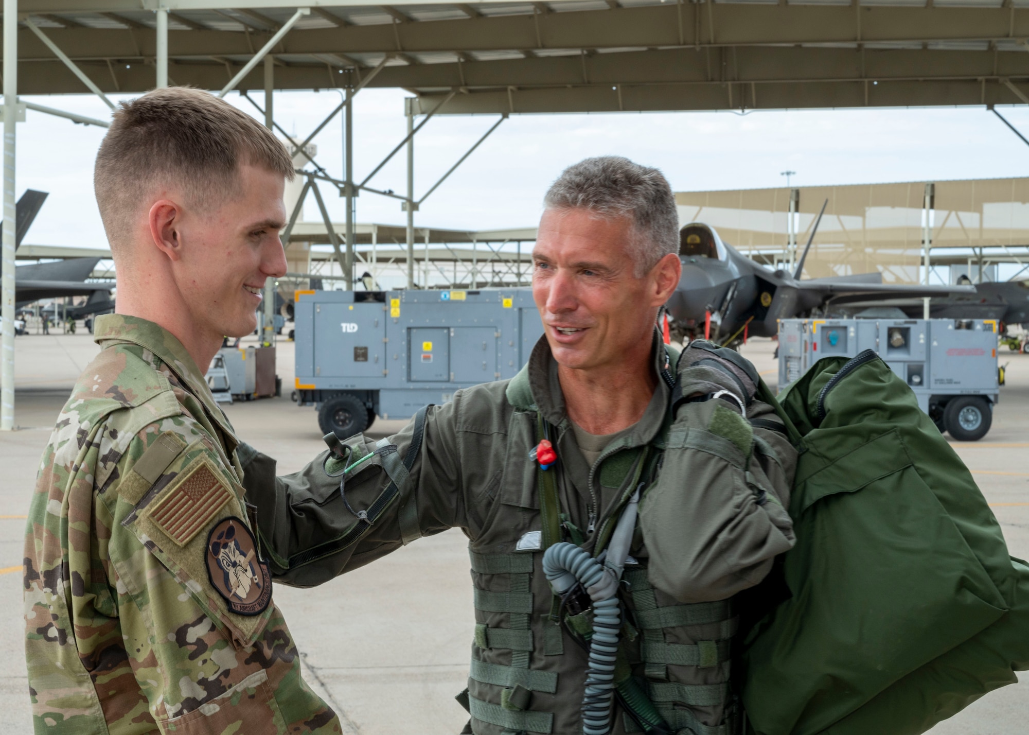 U.S. Air Force Brig. Gen. Gregory Kreuder, 56th Fighter Wing commander, speaks with Senior Airman Aaron Robosky, 61st Aircraft Maintenance Unit dedicated crew chief, before his “fini” flight July 25, 2022, at Luke Air Force Base, Arizona.