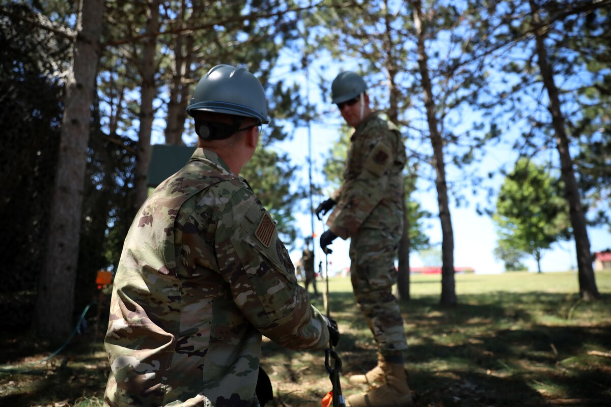 Airman 1st Class James Iwen, a cyber transport specialist with the 128th Air Control Squadron, assists with assembling an antenna during the squadron's annual training at Volk Field, Wis., July 18, 2022.