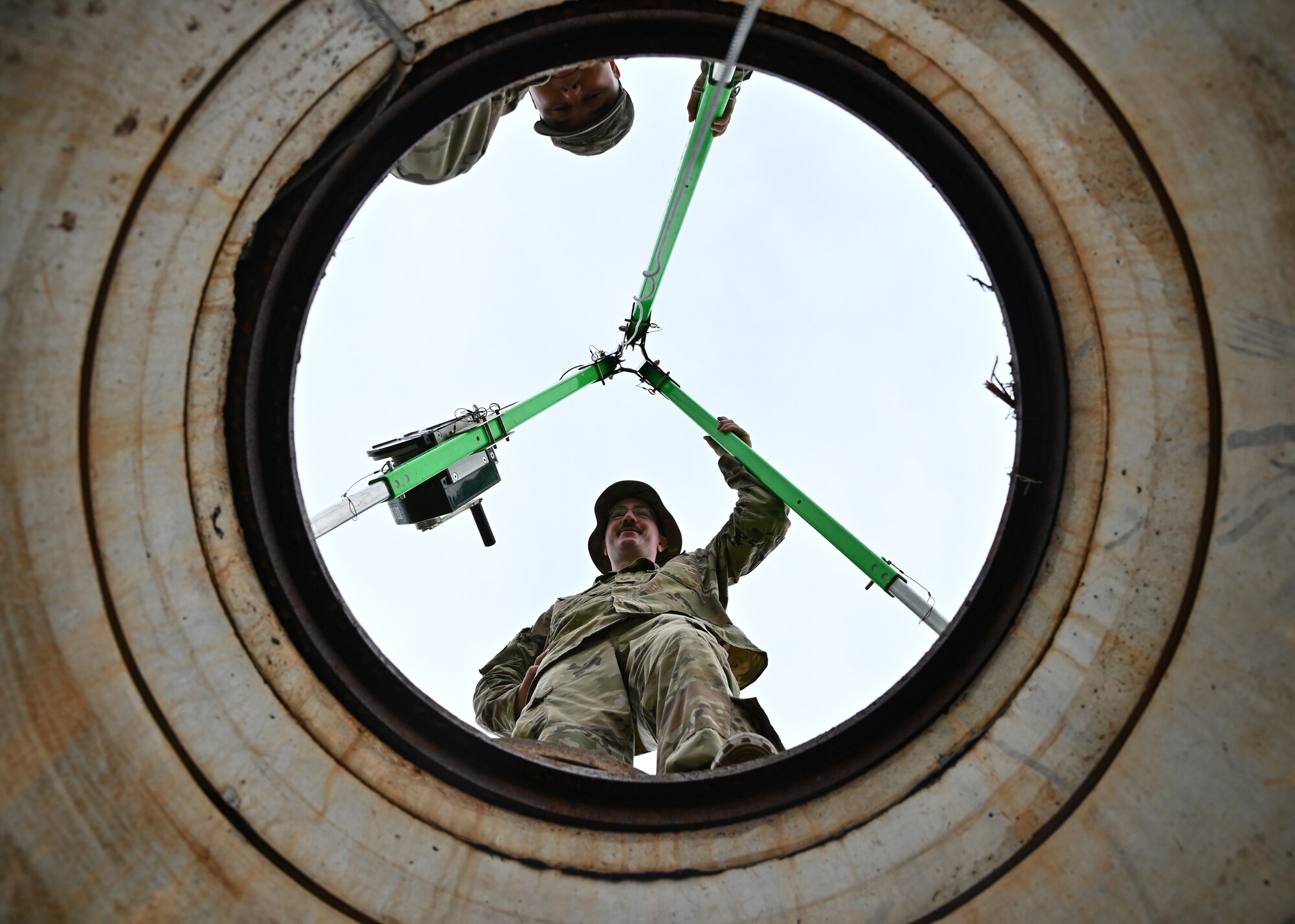 U.S. Air National Guard Tech. Sgt. Christopher Church, 210th Engineering Installation Squadron radar, airfield and weather systems craftsman, acts as an attendant of a telecommunications maintenance hole on Andersen Air Force Base, Guam, July 26, 2022. The attendant’s job is to assess activities and conditions inside and outside of a telecommunications maintenance hole to make certain of the Airman's safety. (U.S. Air Force photo by Airman 1st Class Lauren Clevenger)
