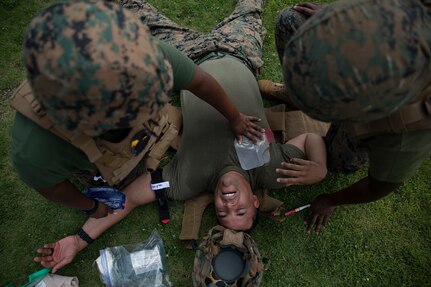 Hospital Corpsman 1st Class Carlton Tucker, a Hospital Corpsman with Marine Aircraft Group (MAG) 12, receives simulated medical care during a Tactical Combat Casualty Care (TCCC) class at Marine Corps Air Station Iwakuni, Japan, July 28, 2022.