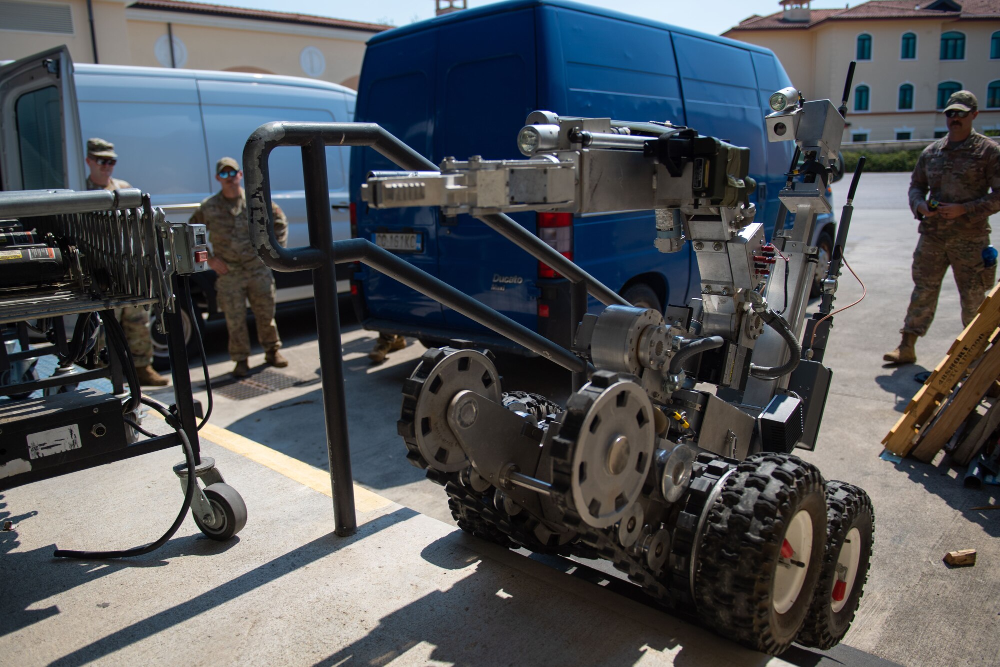 The 31st Civil Engineer Squadron explosive ordnance disposal robot approaches a suspicious package during an exercise at Aviano Air Base, Italy, July 21, 2022. The robot enables the 31st EOD team to observe and disarm explosives from a safe distance. Through a joint effort hosted at the post office, emergency first response units were able to execute training and practice in order to maintain the safety of Aviano AB and its members. (U.S. Air Force photo by Airman 1st Class Thomas Calopedis)