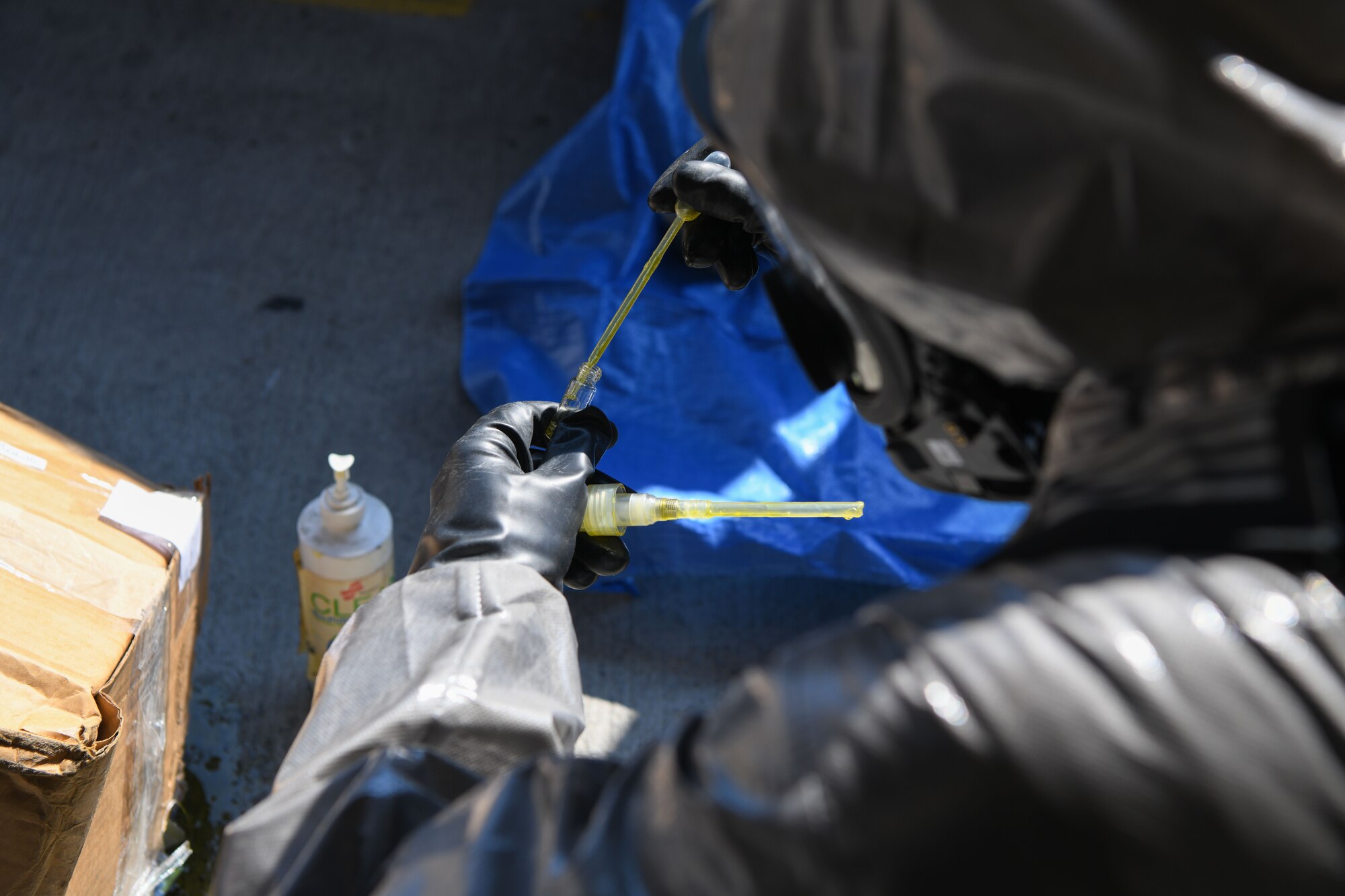 U.S. Air Force Airman Ben Warren, 31st Civil Engineer Squadron emergency management responder, uses a pipette to take a sample of a simulated oily substance during an exercise at Aviano Air Base, Italy, July 21, 2022.  Once a bomb threat is ruled out, Warren responds for chemical analysis of an oily substance present. Exercises provide opportunities to execute training and practice in order to maintain the safety of Aviano AB and its members. (U.S. Air Force photo by Airman 1st Class Thomas Calopedis)