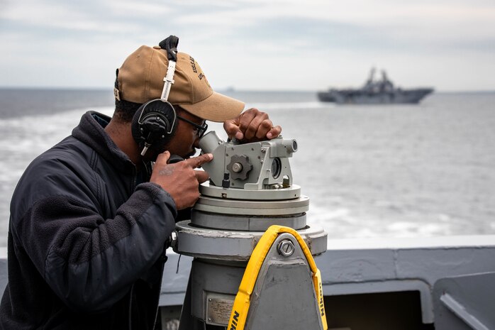 U.S. Navy Quartermaster 3rd Class Donovan Smith, assigned to the San Antonio-class amphibious transport dock ship USS Arlington (LPD 24), stands watch as Arlington sails in formation behind the Wasp-class amphibious assault ship USS Kearsarge (LHD 3) as the ships transit the Danish Straits to enter the Baltic Sea, Aug. 2, 2022.