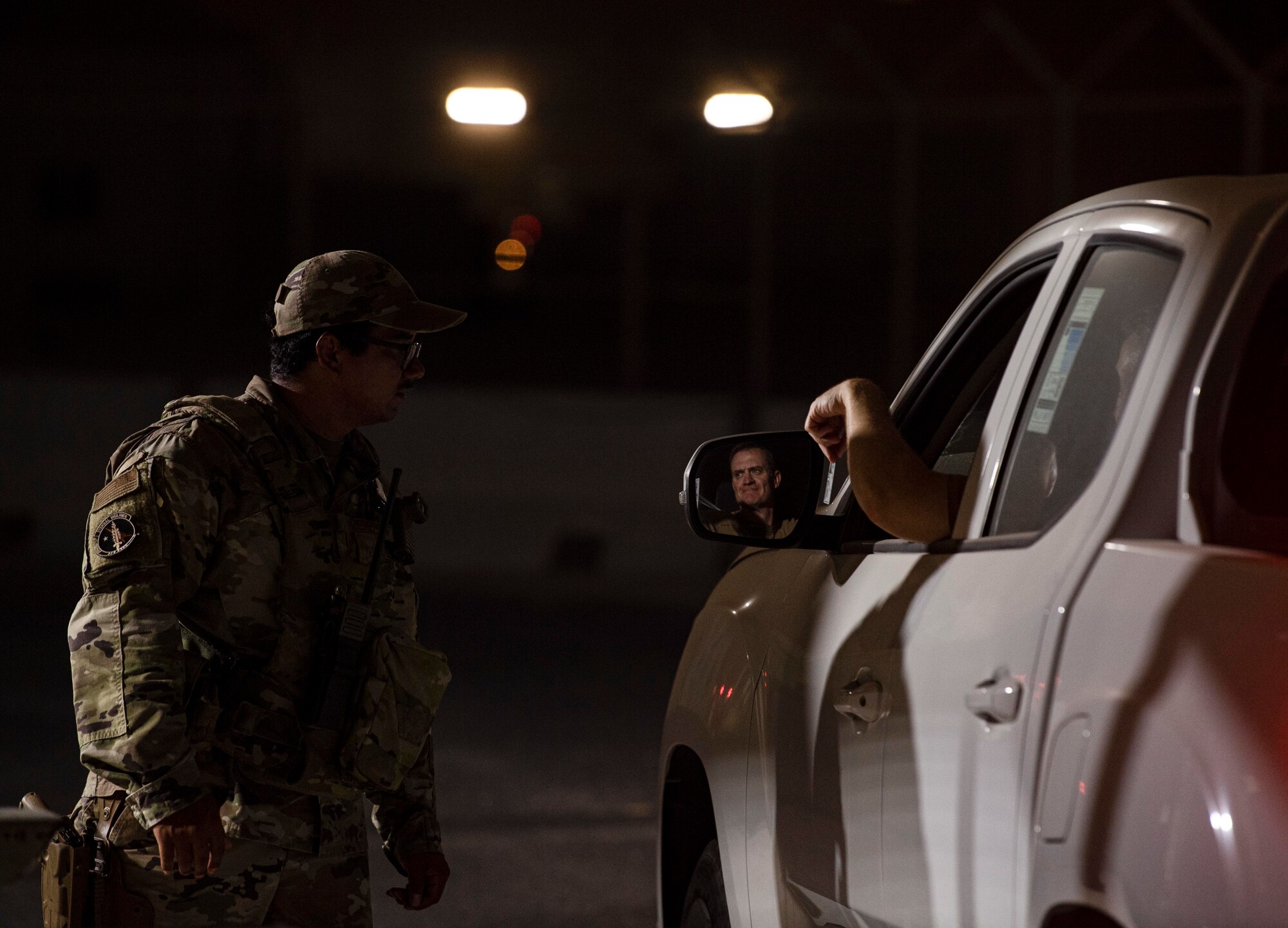 U.S. Air Force Senior Airman Sonny Perez, 379th Expeditionary Security Forces Squadron, checks identification at an entry control point July 25, 2022 at Al Udeid Air Base, Qatar. The ESFS Defenders are responsible for providing 24 hour security for the base. (U.S. Air National Guard photo by Master Sgt. Michael J. Kelly)