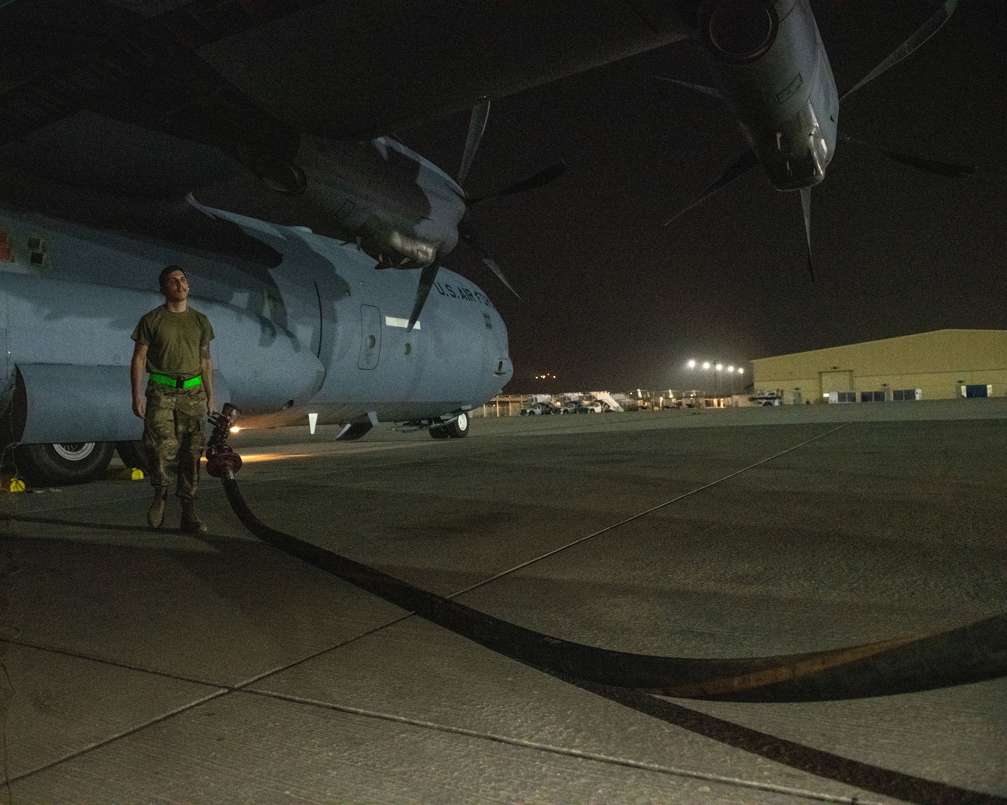 U.S. Air Force Senior Airman Adiel Newman, a distribution operator from the 379th Expeditionary Logistics Readiness Squadron, retrieves a fuel nozzle from a C-130 on Al Udeid Air Base, Qatar, July 18, 2022. Petroleum, Oil and Lubricants specialists are on standby 24/7 for refueling operations. (U.S. Air National Guard photo by Airman 1st Class Constantine Bambakidis)