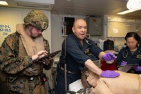 220801-N-IL330-1049 PACIFIC OCEAN (Aug. 1, 2022) – Senior Chief Hospital Corpsman Jorge Acosta, from Chicago, applies a chest seal to a patient during a mass casualty drill in main medical aboard amphibious assault carrier USS Tripoli (LHA 7), August 1, 2022. Tripoli is operating in the U.S. 7th Fleet area of operations to enhance interoperability with allies and partners and serve as a ready response force to defend peace and maintain stability in the Indo-Pacific region. (U.S. Navy photo by Mass Communication Specialist Seaman Austyn Riley)