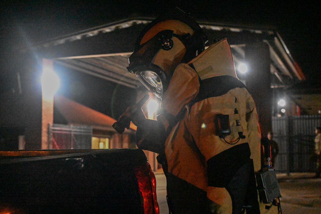 An Airmen shines a flashlight into the back of a truck.