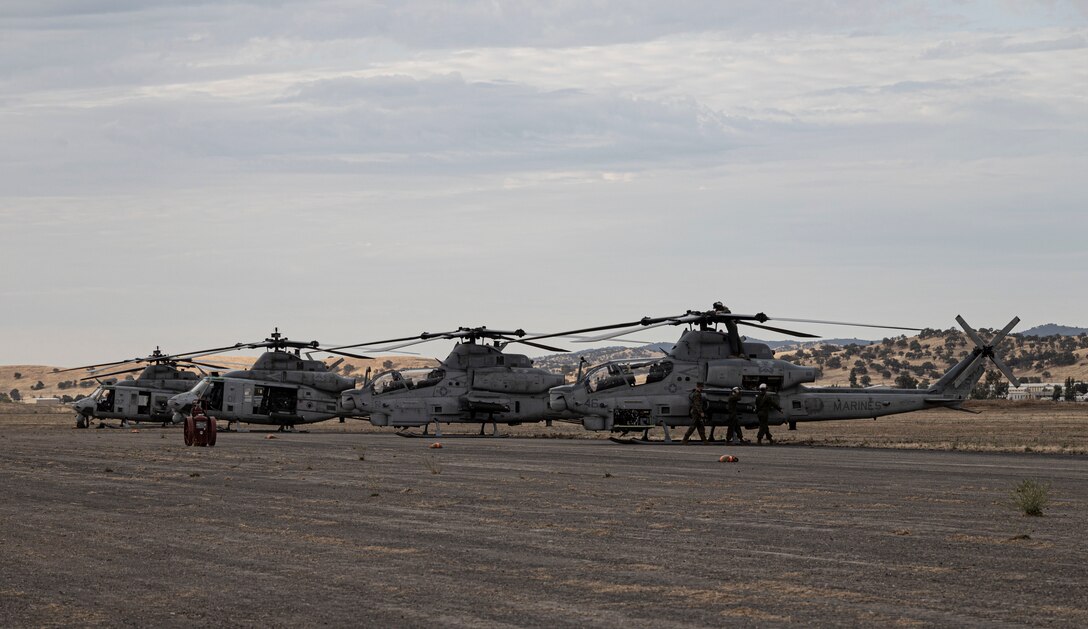 UH-1Y Venoms and AH-1Z Vipers from Marine Light Attack Helicopter Squadron 369, Marine Aircraft Group (MAG) 39, 3rd Marine Aircraft Wing, are staged awaiting flight at Camp Roberts, San Miguel, California, August 1, 2022. MAG-39 is participating in exercise Summer Fury 22, designed to enhance Marine-Air-Ground Task Force integration and increase aviation operations proficiency with realistic, relevant training to ensure the Marine Corps’ largest aircraft wing remains operationally excellent, interoperable, deployable on short notice and lethal when called into action. (U.S. Marine Corps Photo by Cpl. Woodward)