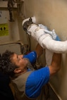 Pasquale Buono, a government contractor, performs maintenance aboard the Whidbey Island-class dock landing ship USS Gunston Hall (LSD 44) during mid-deployment voyage repairs, July 12, 2022.
