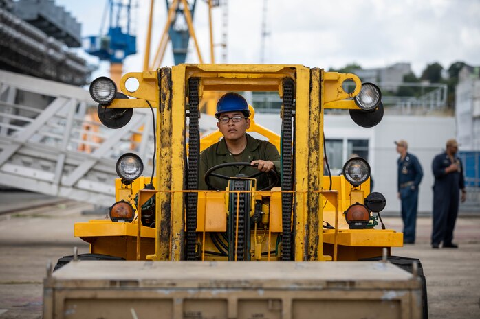 U.S. Marine Corps Lance Cpl. Duane Takala, a network administrator assigned to the 22nd Marine Expeditionary Unit, uses a forklift to maneuver a supply crate designated for the Wasp-class amphibious assault ship USS Kearsarge (LHD 3), during mid-deployment voyage repairs in Brest, France, June 30, 2022.