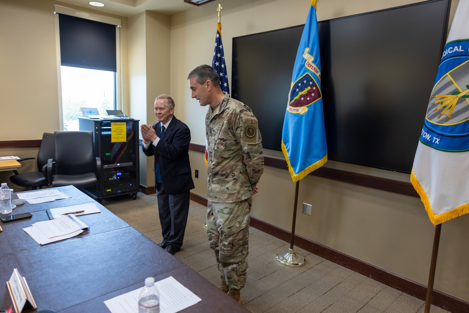 Dr. Barclay Butler, Assistant Director for Support, Defense Health Agency, congratulates Air Force Col. David Walmsley after he became the sixth Commandant of the Medical Education and Training Campus (METC) during a low-key Change of Commandant ceremony held July 21.