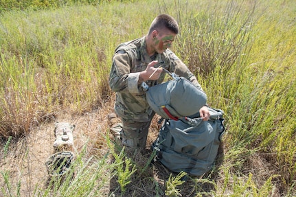 Spc. Michael Pitz, an airborne Soldier with Company C, 2nd Battalion, 134th Infantry Regiment, 45th Infantry Brigade Combat Team, Nebraska Army National Guard, stows his parachute after a high performance jump from a C-130 “Hercules” on Rattlesnake Drop Zone at Fort Chaffee, near Barling, Arkansas, July 23, 2022.  The 2nd Battalion is the newest unit to join the 45th IBCT, bringing with them airborne capabilities that the 45th has not had in more than 50 years. (Oklahoma National Guard photo by Staff Sgt. John Stoner)