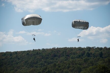 Soldiers from 2nd Battalion, 134th Infantry Regiment, 45th Infantry Brigade Combat Team, Nebraska Army National Guard descend under parachute canopies during airborne operations training from a C-130 “Hercules” on Rattlesnake Drop Zone at Fort Chaffee, Arkansas, July 23, 2022.  The 2nd Battalion is the newest unit to join the 45th IBCT, bringing with them airborne capabilities that the 45th has not had in more than 50 years. (Oklahoma National Guard photo by Staff Sgt. John Stoner)