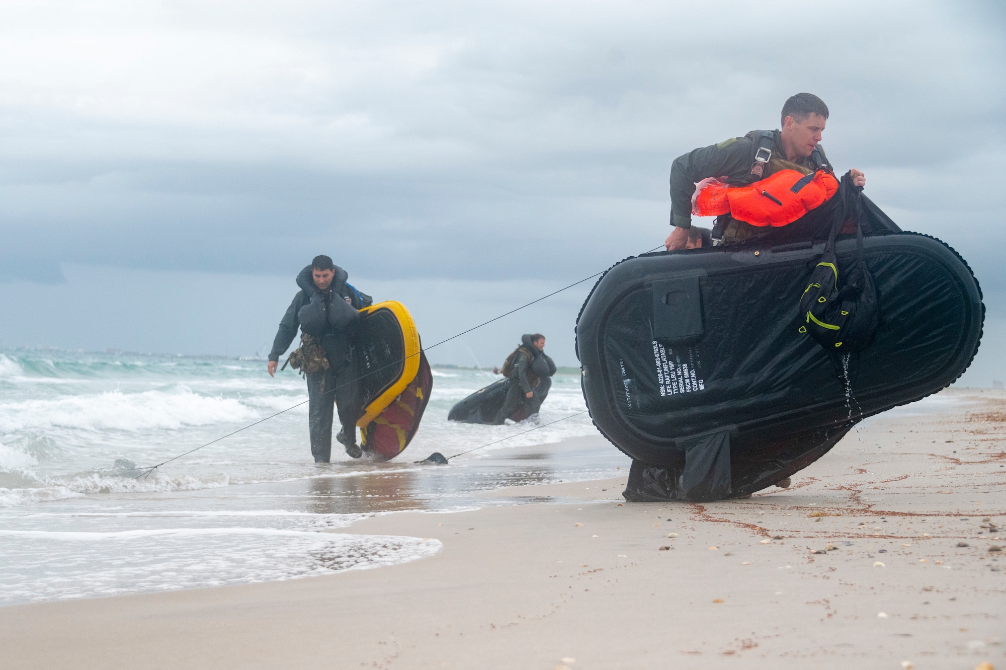 Photo Airmen dragging rafts onto beach.