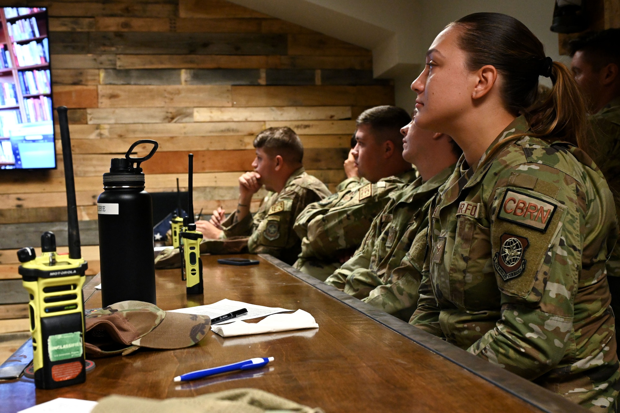 Airmen listen to an instructor in a classroom.