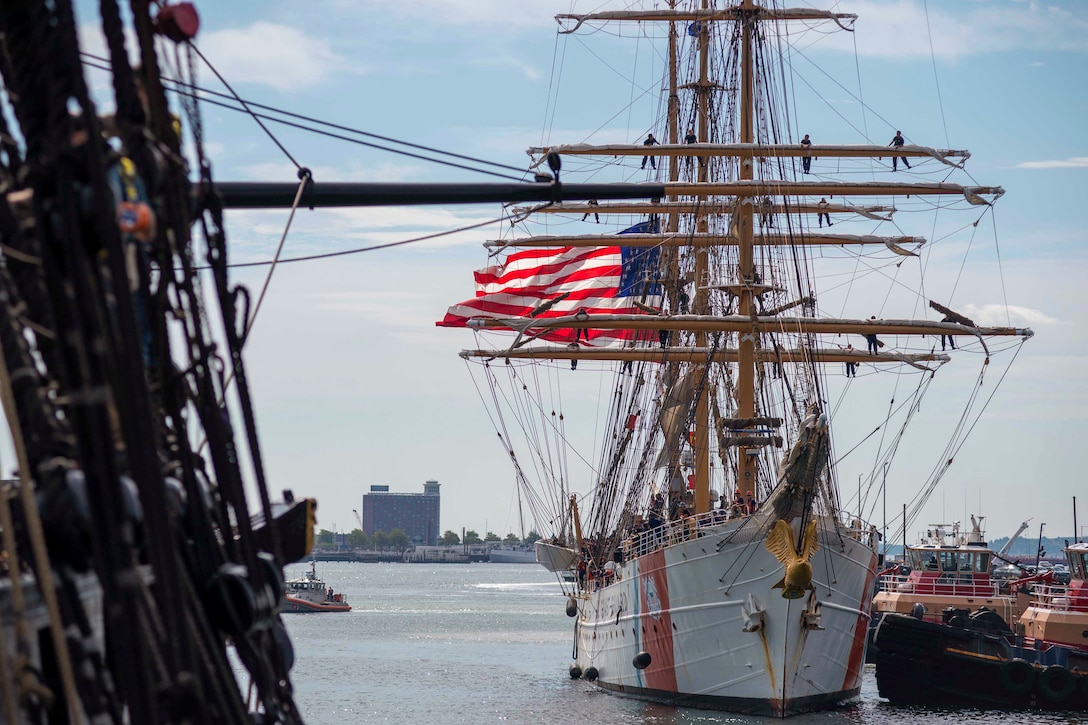 A ship travels next to another where ships are docked.