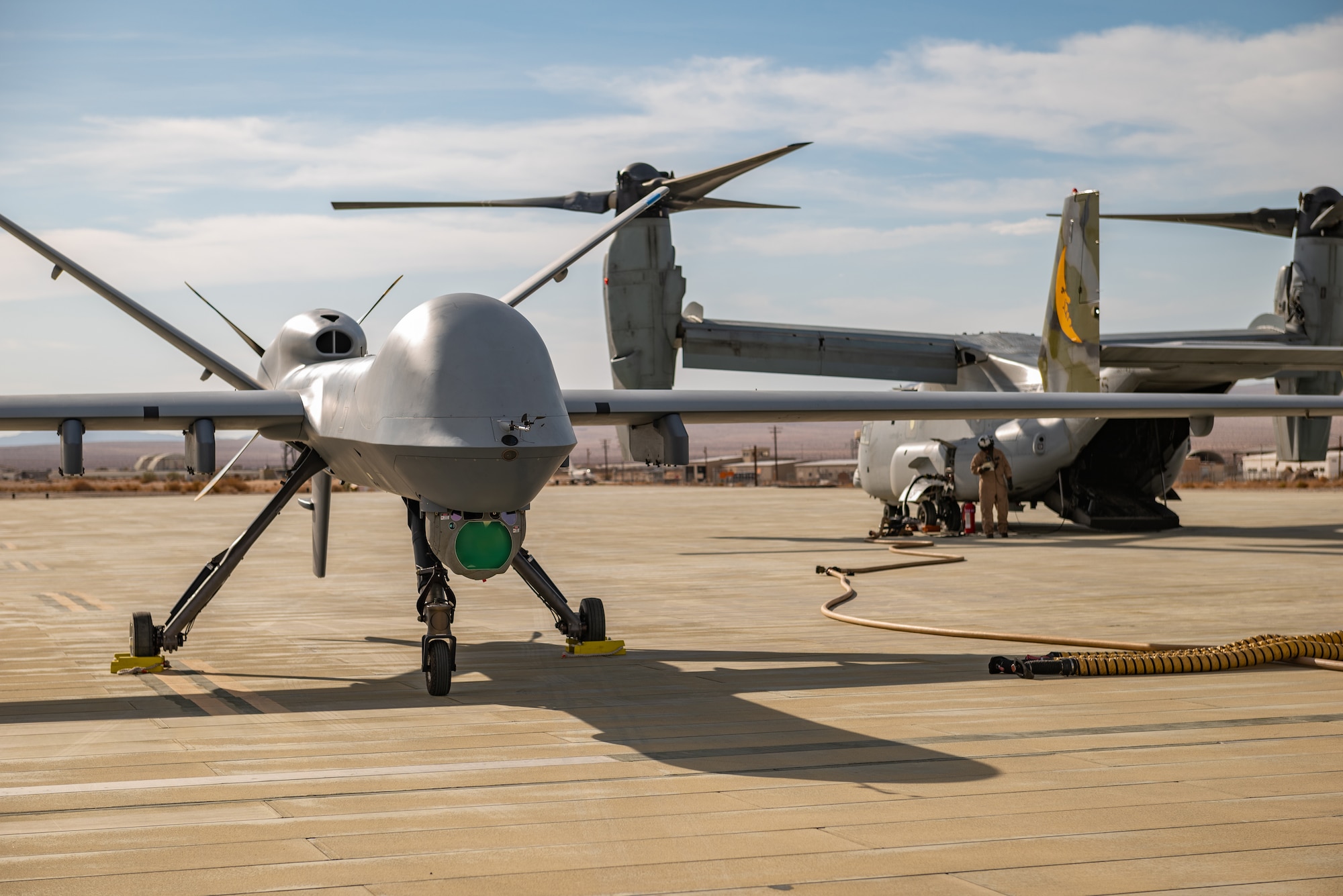 An MQ-9 Reaper assigned to the 163d Attack Wing, March Air Reserve Base stages for refueling on the Strategic Expeditionary Landing Field on Marine Corps Air Ground Combat Center Twentynine Palms, California, July 21, 2022.The 163d accelerated change by pioneering the first ever refuel of the MQ-9 Reaper using a Forward Area refueling Point provided by the VMM - 764’s V-22 Osprey. (U.S. Air National Guard photo by Staff Sgt. Joseph Pagan)