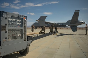 A U.S. Air Force MQ-9 Reaper with the 163d Attack Wing, California Air National Guard, refuels during Integrated Training Exercise (ITX) 4-22 at Marine Corps Air-Ground Combat Center, Twentynine Palms, California, on July 20th, 2022. The MQ-9 Reaper received fuel via aviation delivered ground refueling from an MV-22 Osprey with Marine Medium Tiltrotor Squadron 764, marking the first time the MQ-9 received fuel from a joint asset and the first time an Air National Guard MQ-9 received fuel from another aircraft. The MQ-9 Reaper provided close air support to Marine Air-Ground Task Force 23 during its execution of the fire support coordination exercise of ITX as the Marine Corps Reserve continues to work to integrate with sister services in preparation for future operations. (U.S. Marine Corps photo by Lance Cpl. Jennifer Delacruz)