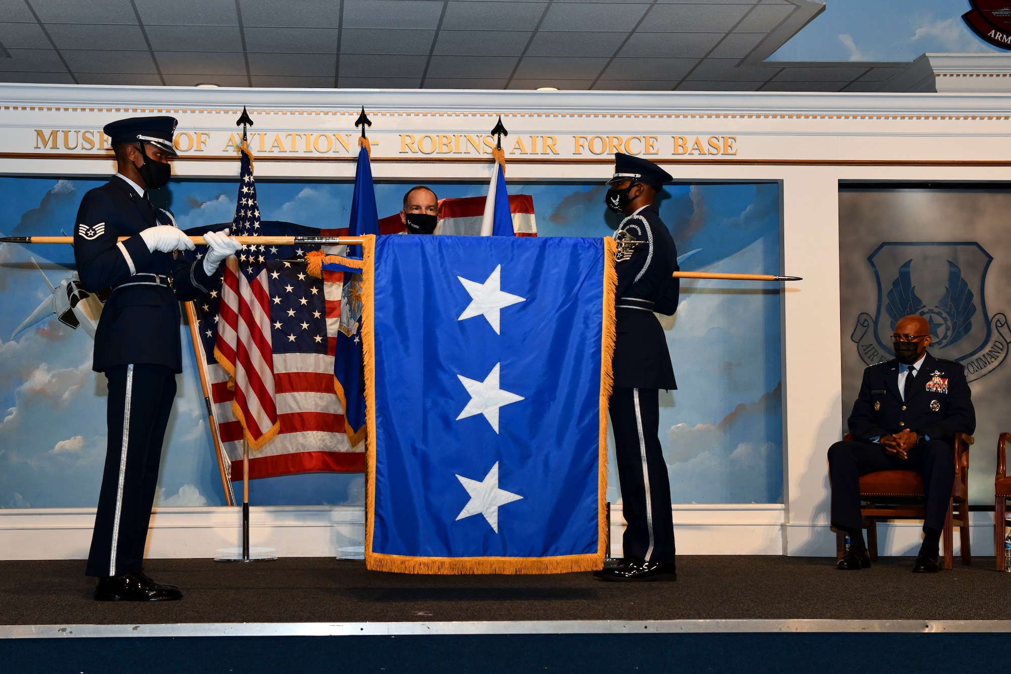 Honor Guard Airmen unfurl a three-star flag