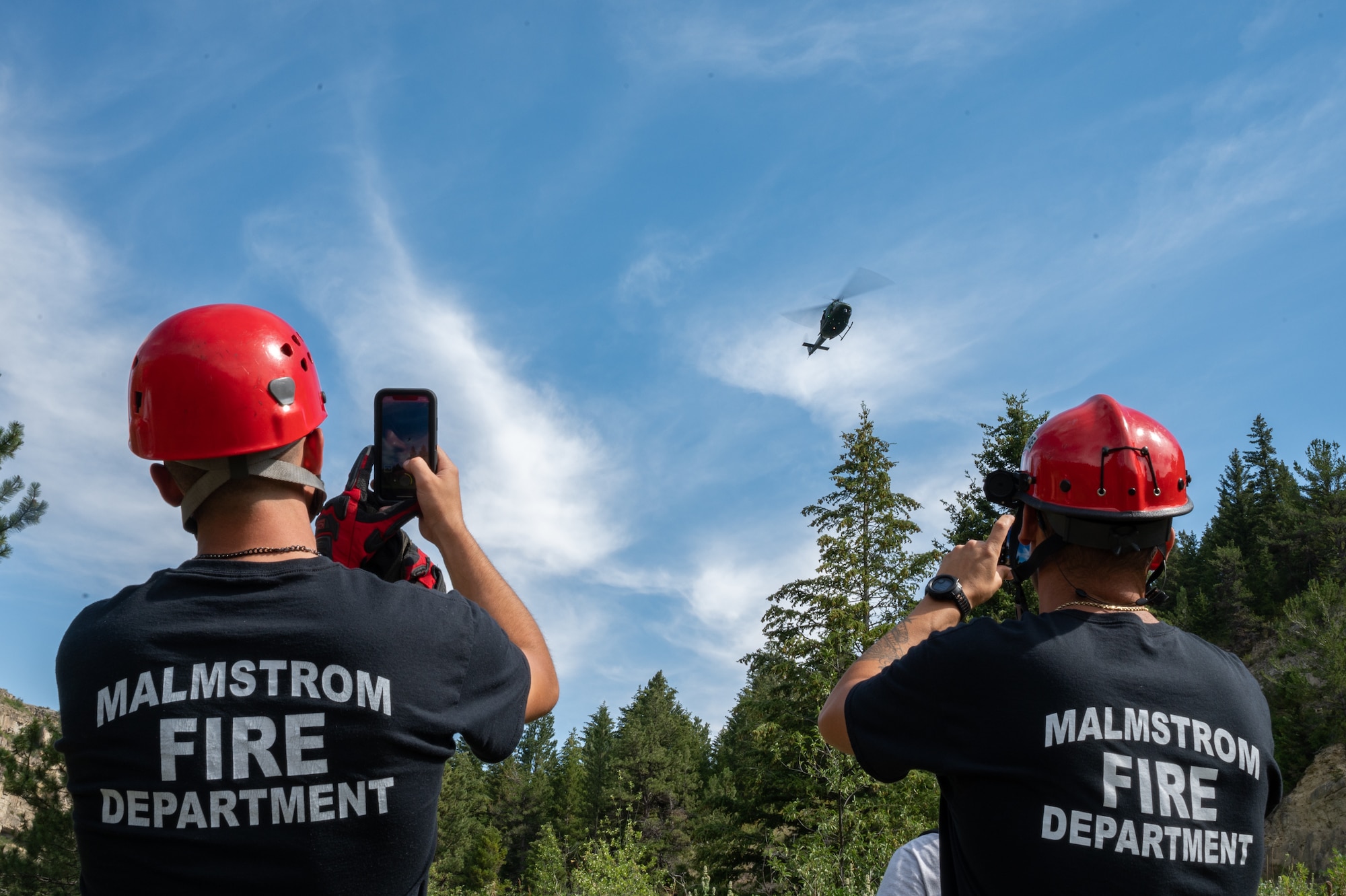 Members of the Malmstrom Fire Department take photos of a UH-N1 Huey helicopter Aug. 2, 2022, in Sluice Boxes State Park, Mont.