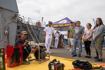 Damage Controlman Fireman Alexander Sparks, assigned to the Arleigh Burke-class guided missile destroyer USS John Paul Jones (DDG 53), gives a damage control demonstration to a tour group during Fleet Week, Aug. 2, 2022. Fleet Week Seattle is a time-honored celebration of the sea services and provides an opportunity for the citizens of Washington to meet Sailors, Marines and Coast Guardsmen, as well as witness firsthand the latest capabilities of today's maritime services. (U.S. Navy photo by Mass Communication Specialist 2nd Class Victoria Galbraith)