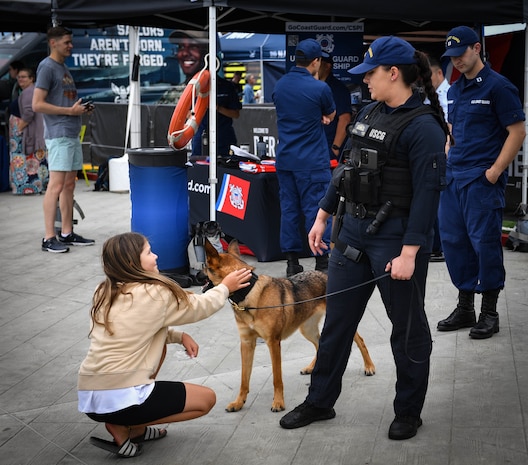 Maritime Enforcement Specialist 2nd Class Alesha Horn speaks with a child about military dog handling at pier 62, August 2 in support of Fleet Week Seattle 2022. Fleet Week Seattle is a time-honored celebration of the sea services that provides an opportunity for the citizens of Washington to meet Sailors, Marines and Coast Guardsmen, and witness the latest capabilities of today’s maritime services. (U.S. Navy photo by Mass Communication Specialist 2nd Class Aranza Valdez)