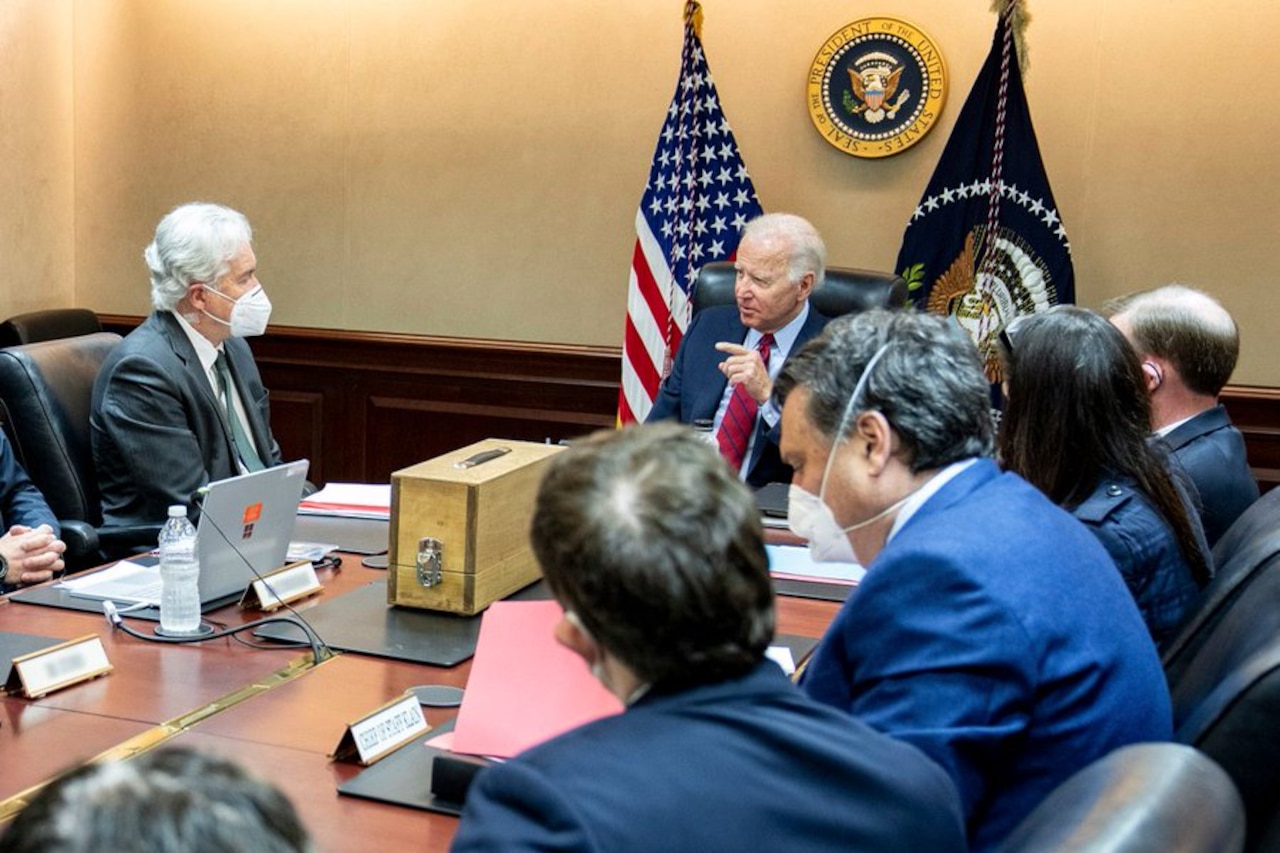 President Joe Biden sits at a desk with his national security team.