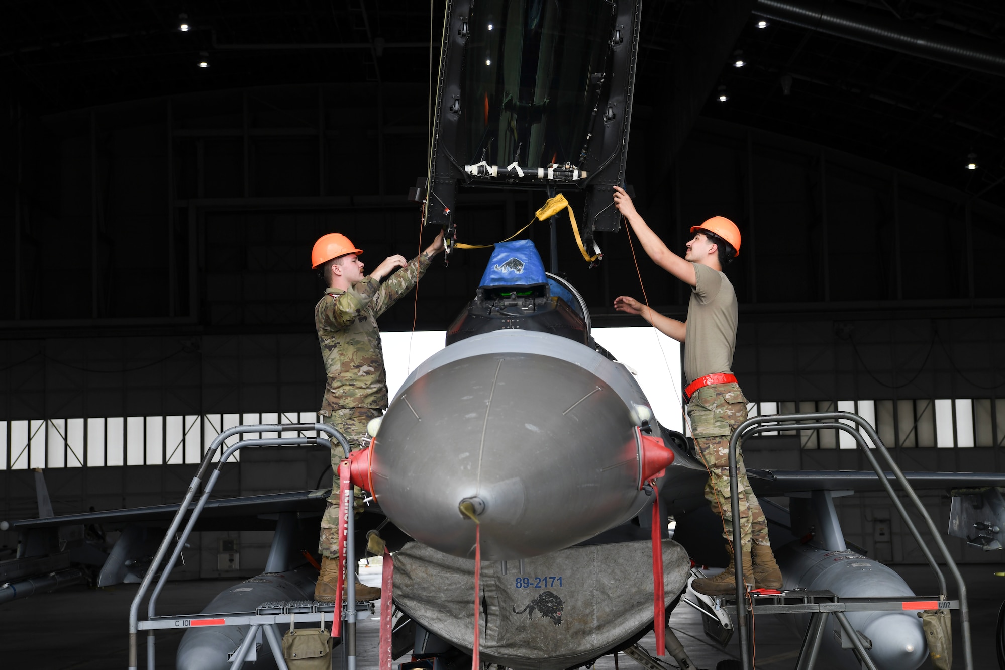 Military members working on a jet.