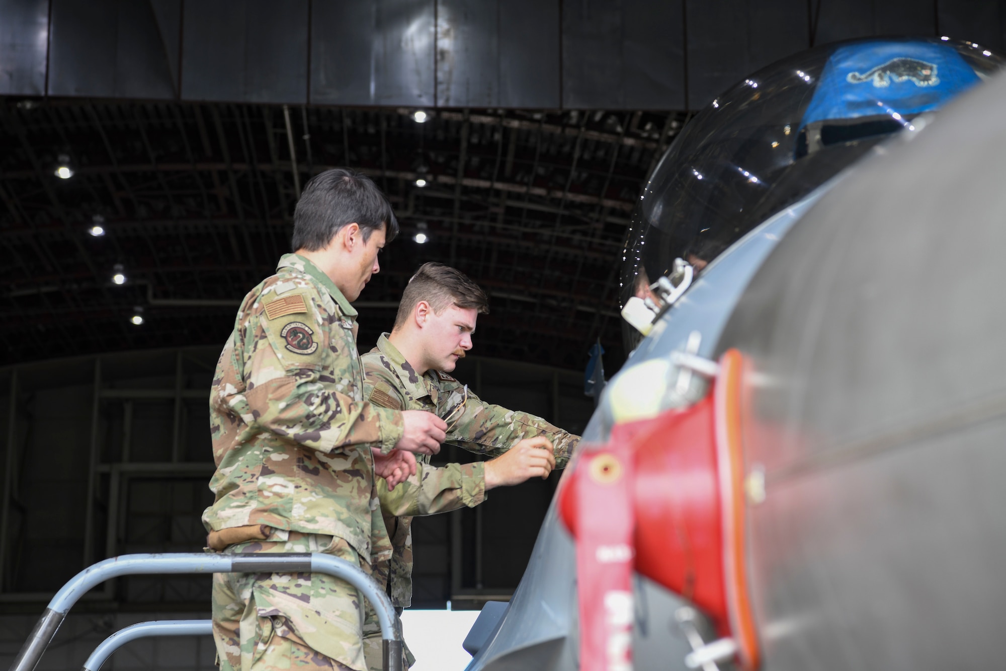 Military members working on a jet